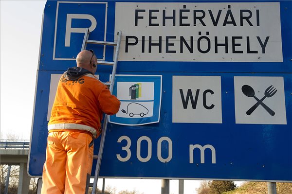 Elektromosautó-töltőállomást előjelző táblát helyeznek ki az M7-es autópálya 57-es kilométerszelvényében, Székesfehérvár közelében, a fehérvári pihenő előtt 2016. december 3-án. MTI Fotó: Lakatos Péter